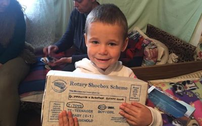 rotary shoebox scheme young boy smiling presents gift